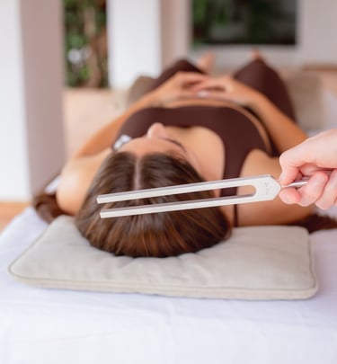 Close up of Sheila Doerfler holding the 174 Hz tuning fork above client's crown activating sun star
