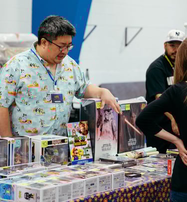 A vendor gestures to some of the nerdy items he has for sale.