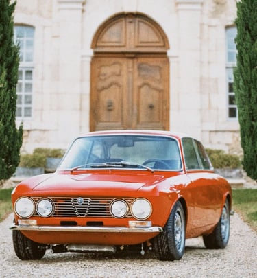 An image of a red 1974 Alfa Romeo lined by two rows of trees