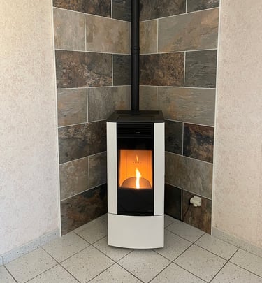 Installation de poêle à granulés design en angle avec habillage en pierre