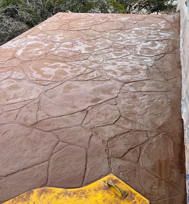 Colored and stamped concrete balcony after waterproofing deck.