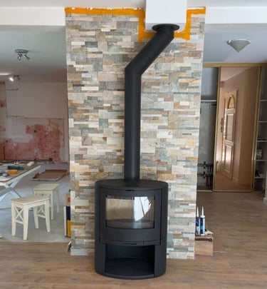 Installation de poêle à bois moderne avec mur en pierre naturelle