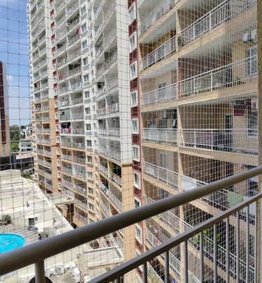 Evening shot of a residential building in Bengaluru with multiple balconies fitted with safety nets 