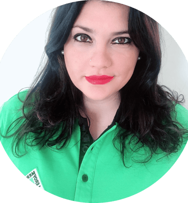 Professional portrait of a woman with dark wavy hair wearing a green polo shirt.