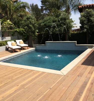 a pool with a wooden deck and a 3 separate water features