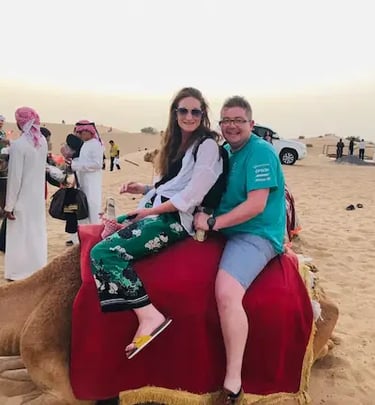 Couple enjoying a camel ride in the Dubai desert during a desert safari