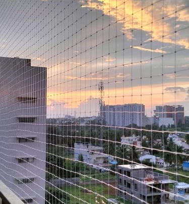 A family enjoying their balcony safely enclosed with a net, demonstrating peace of mind from Arjilli