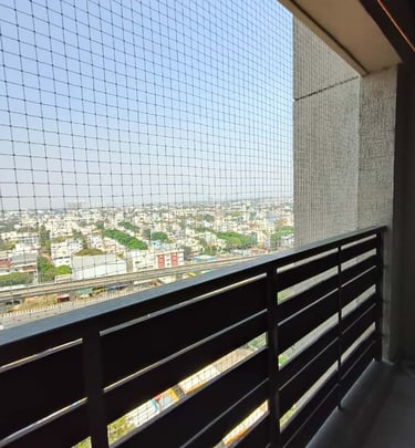 Technician from Arjilli Enterprises installing a safety net on a residential balcony