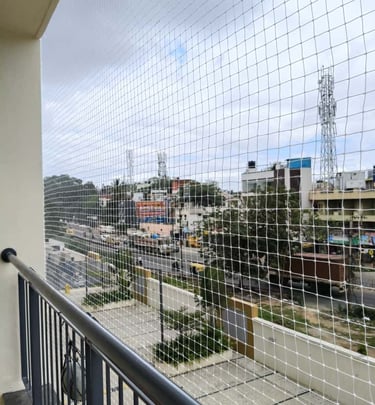 A child playing safely behind a sturdy balcony net installed by Arjilli Enterprises