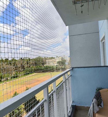 Close-up of a sturdy balcony safety net tightly secured on a residential balcony in Thiruvanmiyur