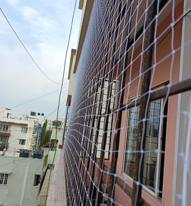 Close-up of a sturdy net tightly secured around an apartment duct area, preventing pigeons from ente