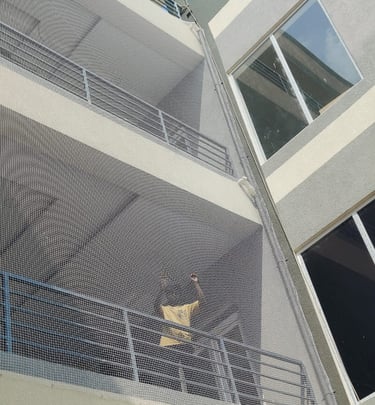 Evening view of a balcony with a safety net glowing softly under warm lights, ensuring safety withou
