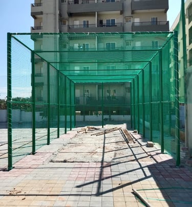 Technician from Arjilli Enterprises carefully securing a net around a basketball court fence