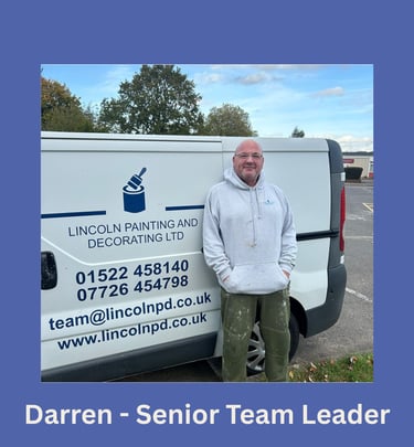 Portrait of Darren, a senior team leader, smiling and standing next to his branded van.