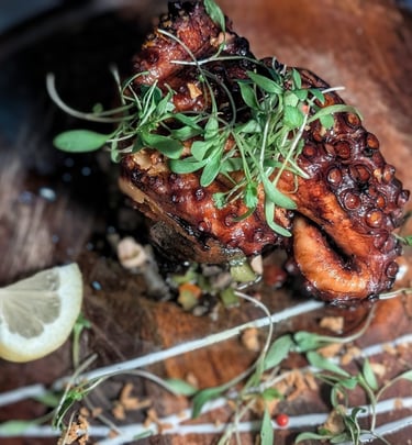 Santa Luzia Octopus on a bed of roasted sweet potato with chopped peppers and olives