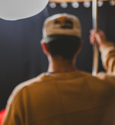Man setting up a c-stand with a light in a podcast studio in Dallas, Texas.