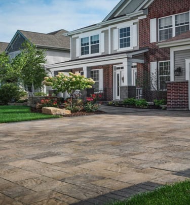 a brick paver driveway with earthy colors and dark border
