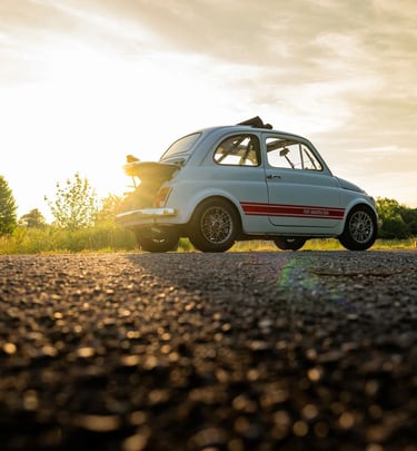 A rear quarter shot of a 1974 Fiat 595SS Abarth at sunset