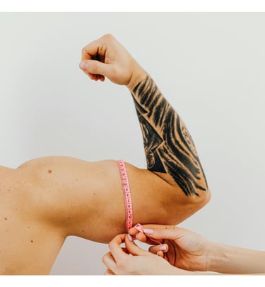 Profissional fazendo medição do bíceps de um homem com uma fita métrica rosa