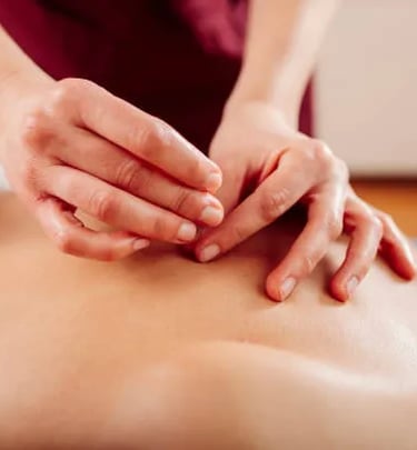 Profissional fazendo aplicação de agulha de acupuntura nas costas do paciente deitado