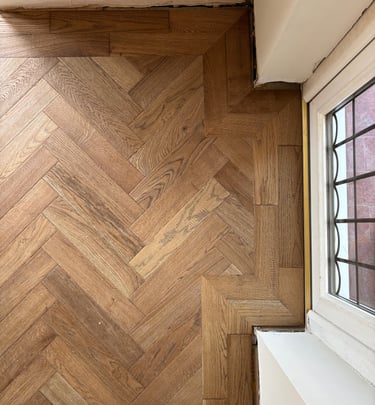 A brown oak herringbone floor with a double border