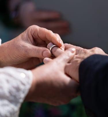 Bride placing a wedding ring on a groom's finger