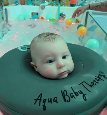 bébé dans le bain avec une bouée de cou