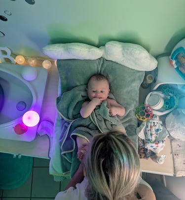 bébé après un bain se faisant masser par la praticienne