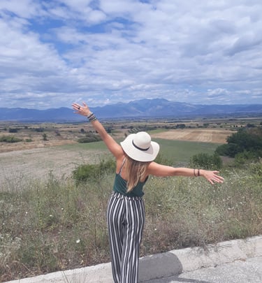 Martina outdoors with arms outstretched.