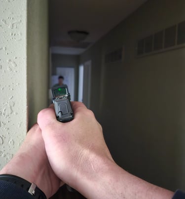 Individual using a personal firearm and self-defense tactics during home defense training.