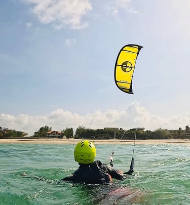 pessoa controlando o kitesurf dentro da água.