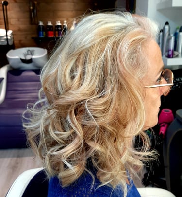 Une femme aux cheveux blonds avec des lunettes sur la tête.