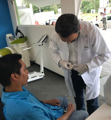 Médico realizando una prueba médica a un paciente en una unidad móvil de salud ocupacional.