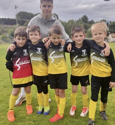a man standing next to a group of young boys