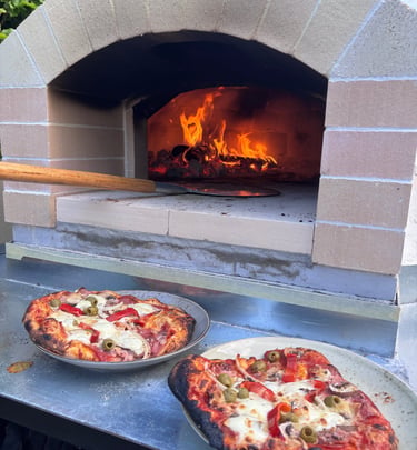 Leckere Pizza vor offenem Feuer