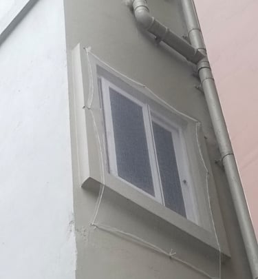 Technician carefully installing a safety net on a residential balcony in Bengaluru with tools in han