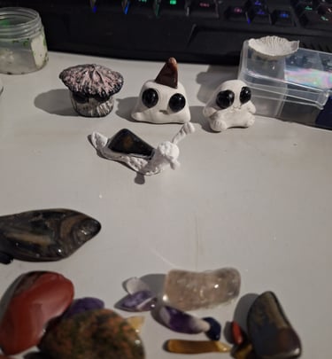 Handmade clay mushoom and snail figurines with crystals and gemstones still to be used.
