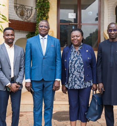 Professional group of African business leaders posing together outdoors in formal attire for a corporate meeting.