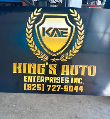 Custom gold and black King's Auto Enterprises Inc. business sign with 3D logo and contact phone number.