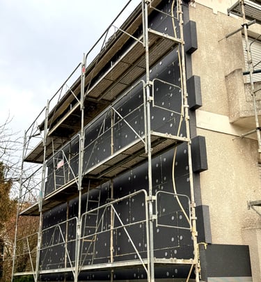 chantier en cours façade de maison avec pose de plaques isolantes et chevilles