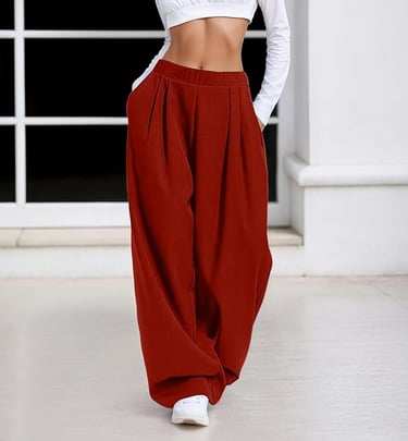 Woman wearing high-waisted red wide-leg trousers and a white crop top long sleeve shirt.