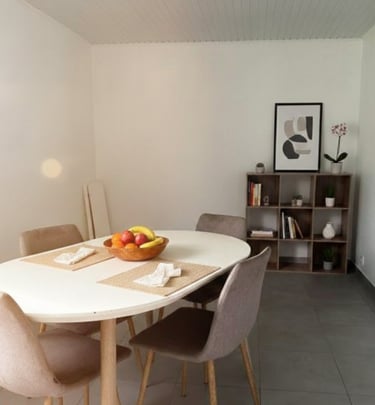 Coin repas lumineux avec table ronde et décoration moderne – location saisonnière à Ducos Martinique