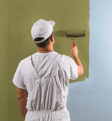 Person painting an interior wall with a roller.