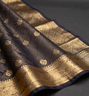 Office wear saree in muted tones with clean lines, paired with a simple blouse on a wooden hanger