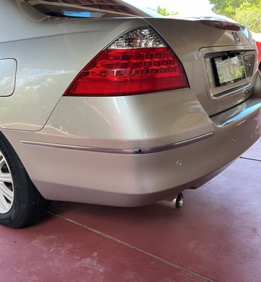 Rear view of a silver Honda Accord showing freshly refinished taillight, bumper, and exhaust pipe.