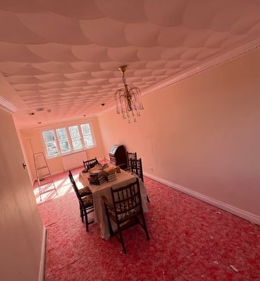 A freshly painted lounge with a antique dining table and chandelier 