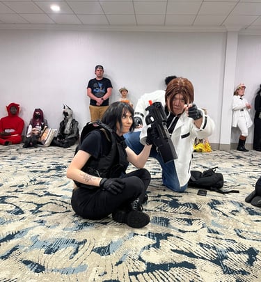 Two anime con attendees posing for a photo while sitting on the ground, enjoying themselves
