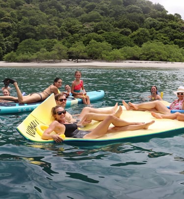Guests enjoying floating mats and water activities during luxury catamaran experience in Papagayo