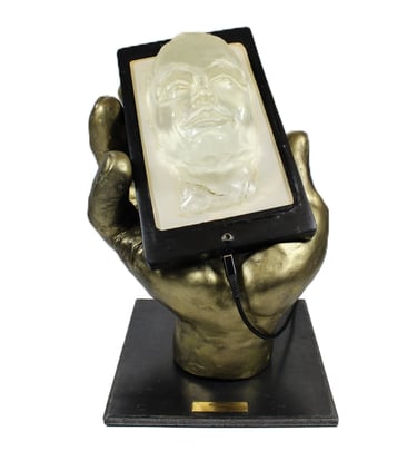 Lode sculpture intitulée Narcisse représentant une main tenant un téléphone avec un visage qui sort de l'écran