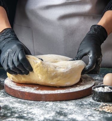 a person wearing gloves and gloves while making a doughnut